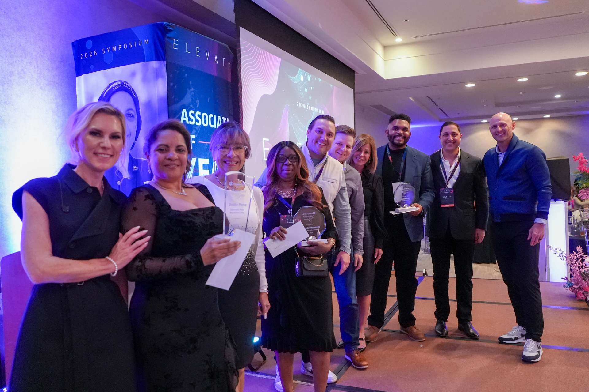 Associate of the Year nominees pose together on stage.